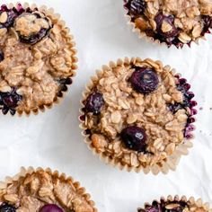 four blueberry oatmeal muffins on top of white parchment paper