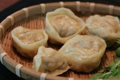 steamed kimchi dumplings on a bamboo basket with parsley