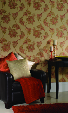 a living room with a chair and table in front of a wallpapered wall