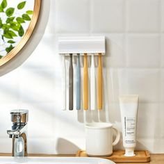 a bathroom sink with soap dispenser, toothbrush holder and lotion