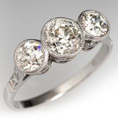 three stone diamond ring in white gold with diamonds around the band and sidestones on each side