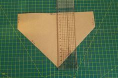 a piece of paper that has been cut into triangles on a cutting mat with a ruler