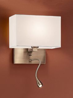 a wall light with a white shade on it's side and a brown wall in the background