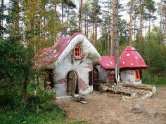 an image of a mushroom like house in the middle of the woods with red roof and windows