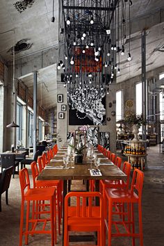 an image of a dining room with red chairs and a chandelier hanging from the ceiling