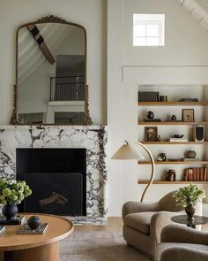 a living room filled with furniture and a fire place in front of a large mirror