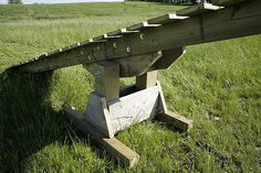 an old wooden bench sitting in the middle of a field