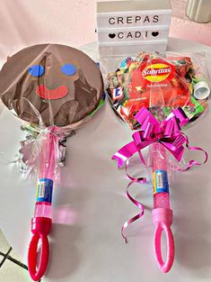 two pink umbrellas sitting on top of a table next to a candy bar bag