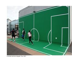 several people are playing tennis on a green court with white lines painted on the ground