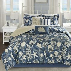 a bed with blue and white comforters in a bedroom