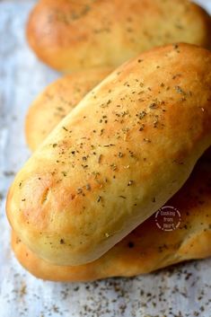 some bread is laying on a piece of wax paper and sprinkled with seasoning