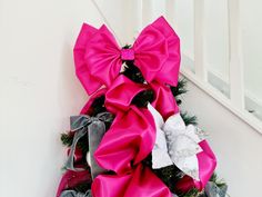 a christmas wreath with pink and white bows