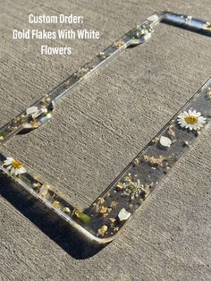 the bottom part of a phone case that has flowers in it and is laying on the ground