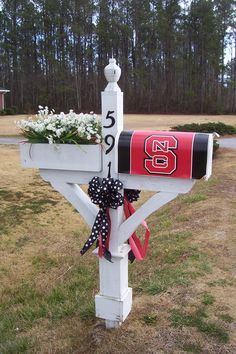 a mailbox decorated with flowers and a ribbon tied around the letter's post