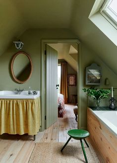 an attic bathroom with green walls and wooden floors