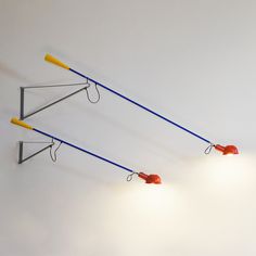 two lamps that are hanging from the ceiling with wires attached to them and one light is on