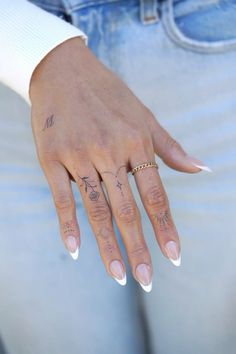 a woman's hand with tattoos on her left and right fingers, showing the ring finger tattoo