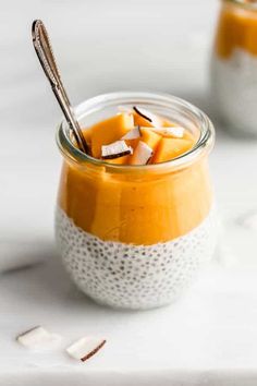 two small jars filled with pudding and topped with marshmallows, on a white surface