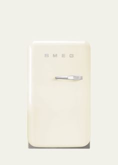 a white refrigerator freezer sitting on top of a counter next to a wall mounted toothbrush