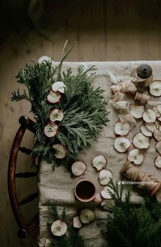 an arrangement of vegetables and herbs on a table cloth with wooden utensils next to them