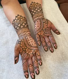 two hands with henna tattoos on them