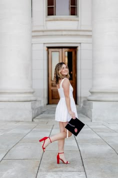 a woman in white dress and red high heels