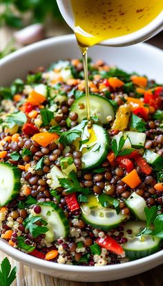 a bowl filled with vegetables and dressing being drizzled on top of it