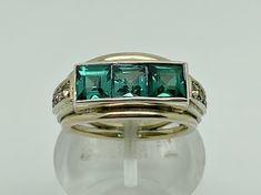 A gorgeous vintage art deco 835 grade silver tank ring set with three square cut green lab spinesl and small glass paste stones in each shoulder. Maker/Markings: Marked 835 for Silver Condition: Very Good Used Condition, some fading to the gold finish otherwise general patina/wear - Please look at photos Measurements: UK RING SIZE M - US RING SIZE 6 - Green stone setting 15 x 5mm Weight: 5.6g Tank Ring, Antique Jewelry Rings, Antique Jewellery, Green Stone, Stone Settings, Vintage Art Deco, Vintage Watches, Ring Set, Jewellery And Watches