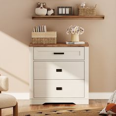 a white dresser with drawers and shelves in a room next to a chair, bookshelf and stuffed animal