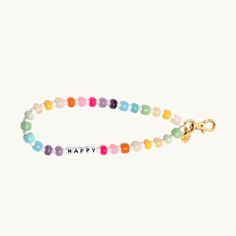 a colorful beaded bracelet with the words happy on it and a gold charm in front