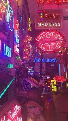 many neon signs are lit up in the dark