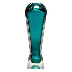 a blue glass vase sitting on top of a table