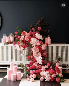 pink flowers and candles are arranged on a black and white checkered floor