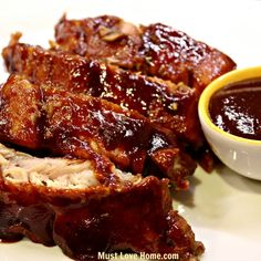 barbecue ribs with bbq sauce on the side and dipping sauce in a small bowl