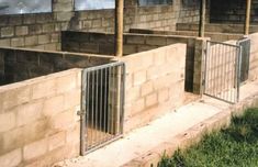 an unfinished building with metal bars on the sides and grass growing in front of it