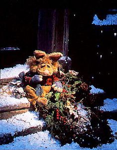 a stuffed animal sitting on top of snow covered ground