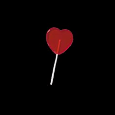 a red heart lollipop on a black background