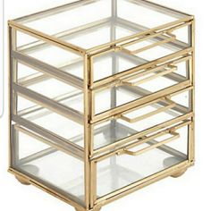 a gold and glass jewelry box with five compartments on each side, all stacked together