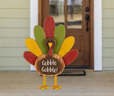 a wooden turkey sign with the words gobble gobble written on it in front of a door