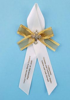 a white and gold ribbon with a cross on the end is attached to a blue background