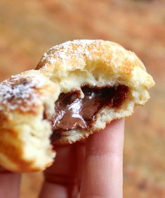 a hand holding a half eaten chocolate filled pastry