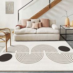 a living room with a white rug and black circles on the floor next to a stair case