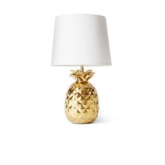 a gold pineapple lamp with a white shade