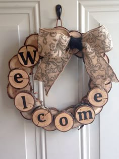 a wreath made out of wood slices with the word welcome on it