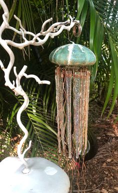 a white bird bath sitting on top of a lush green forest