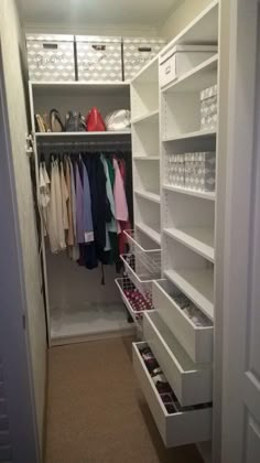 an organized closet with white shelving and drawers