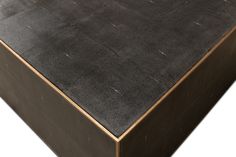 a close up view of the top of a black leather table with gold trimmings