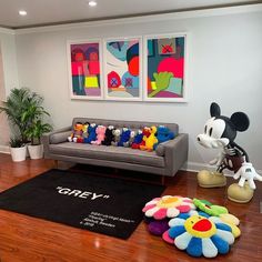 a living room filled with furniture and mickey mouse figurines on top of a hard wood floor