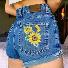 the back of a woman's jean shorts with sunflowers on it