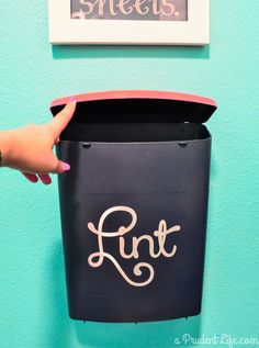 a hand is holding a black trash can with the word runt painted on it